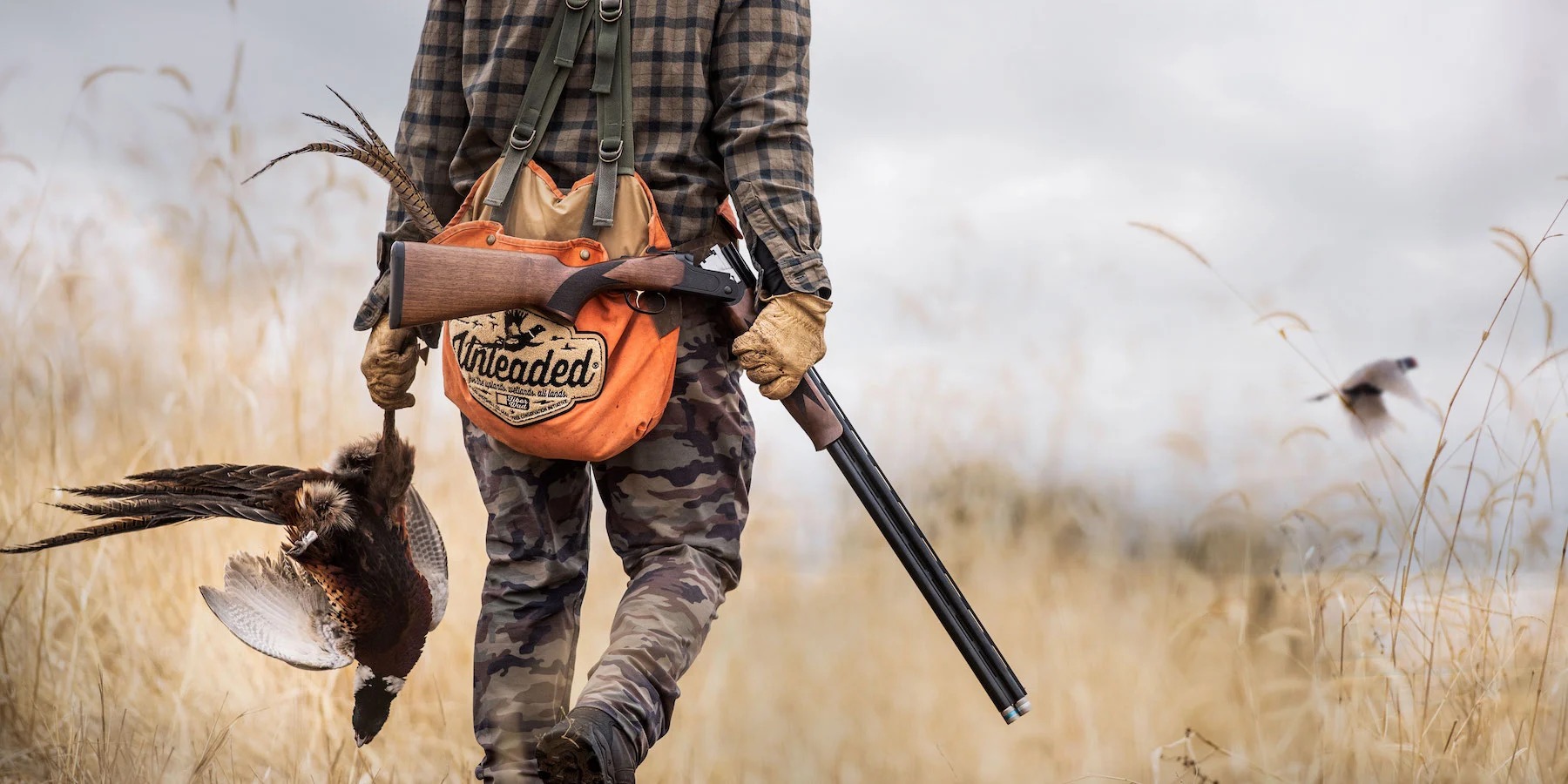A Mossberg shotgun carried through a field.